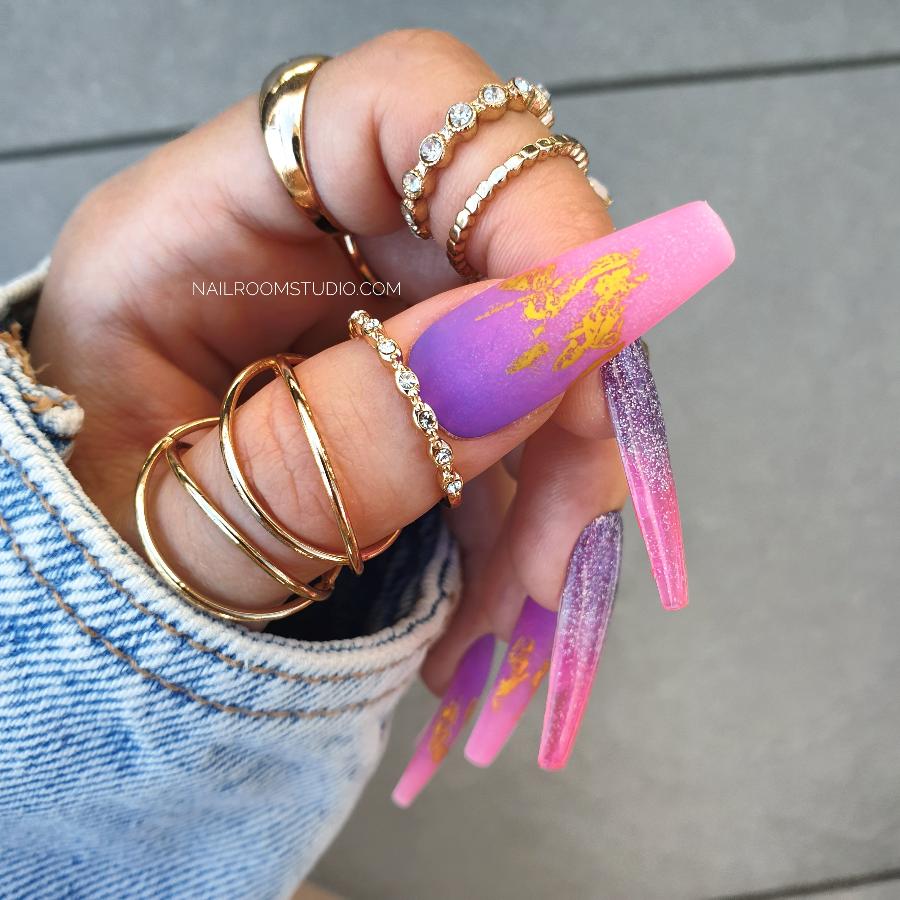 Energetic and sunny pink to purple ombre coffin nails, featuring a matte finish with gold chrome highlights, partially transparent glossy effect for a standout look from Nail Room Studio