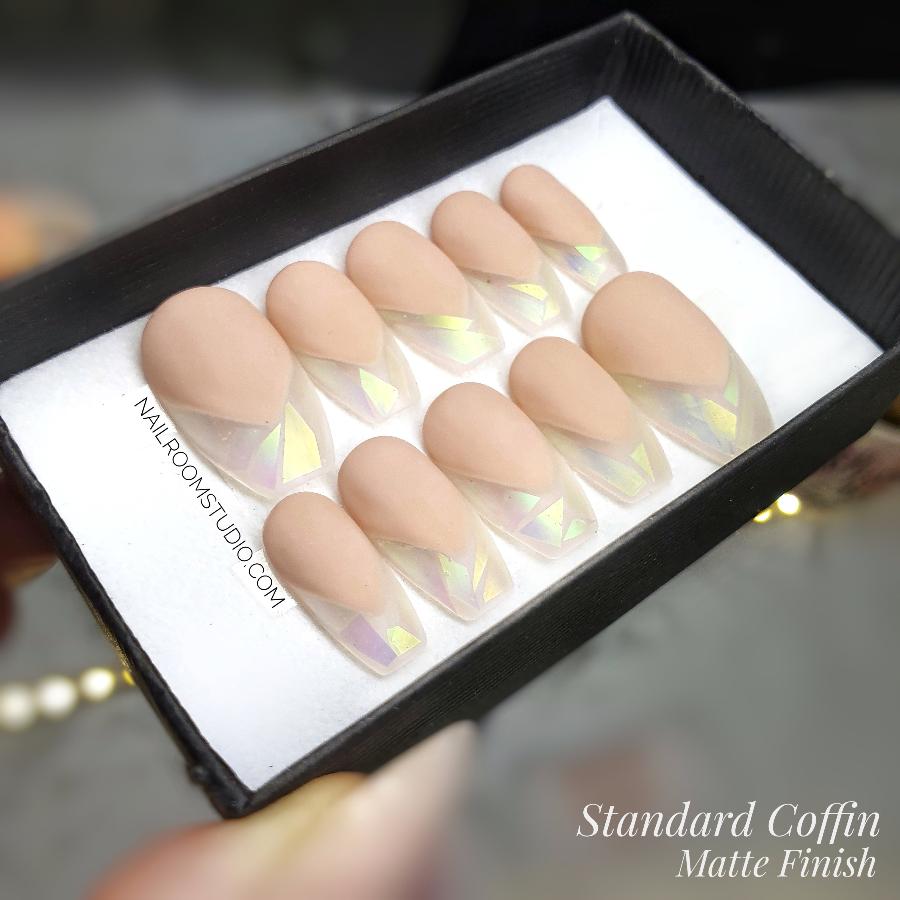 Long custom stiletto nails with nude french style, iridescent broken glass, and opal accents from Nail Room Studio