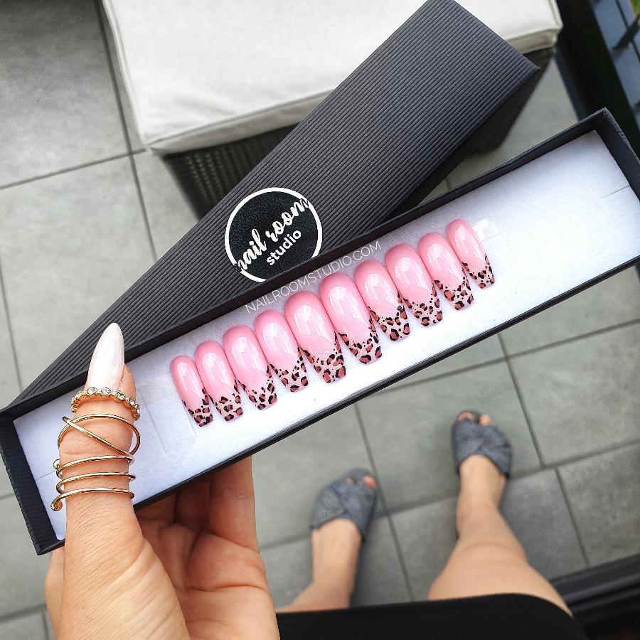 Adorable pink nails featuring whimsical leopard prints in a chic French style, ideal for a lively and stylish vibe by Nail Room Studio