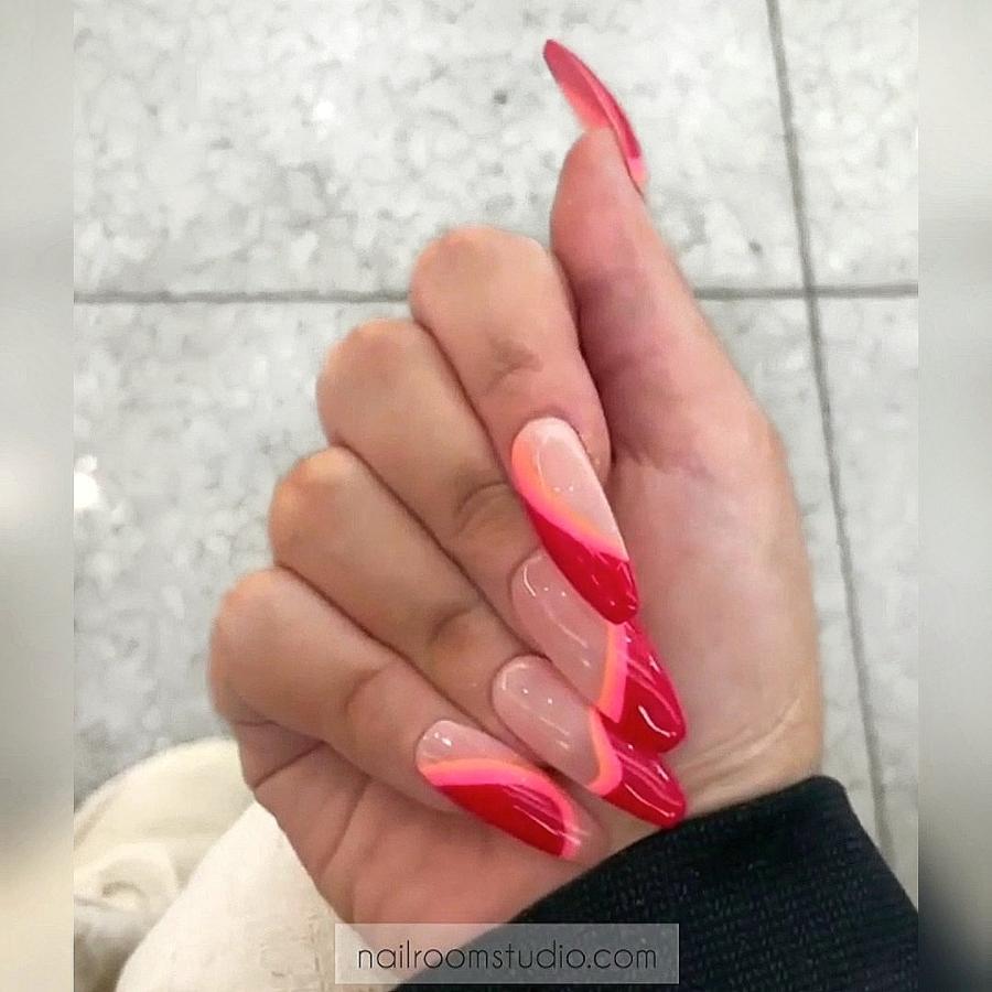 Nude and red press-on nails featuring wavy and geometric patterns with vibrant Coca-Cola red and orange stripes, great for a bold and unique look, ideal for dark skin tones