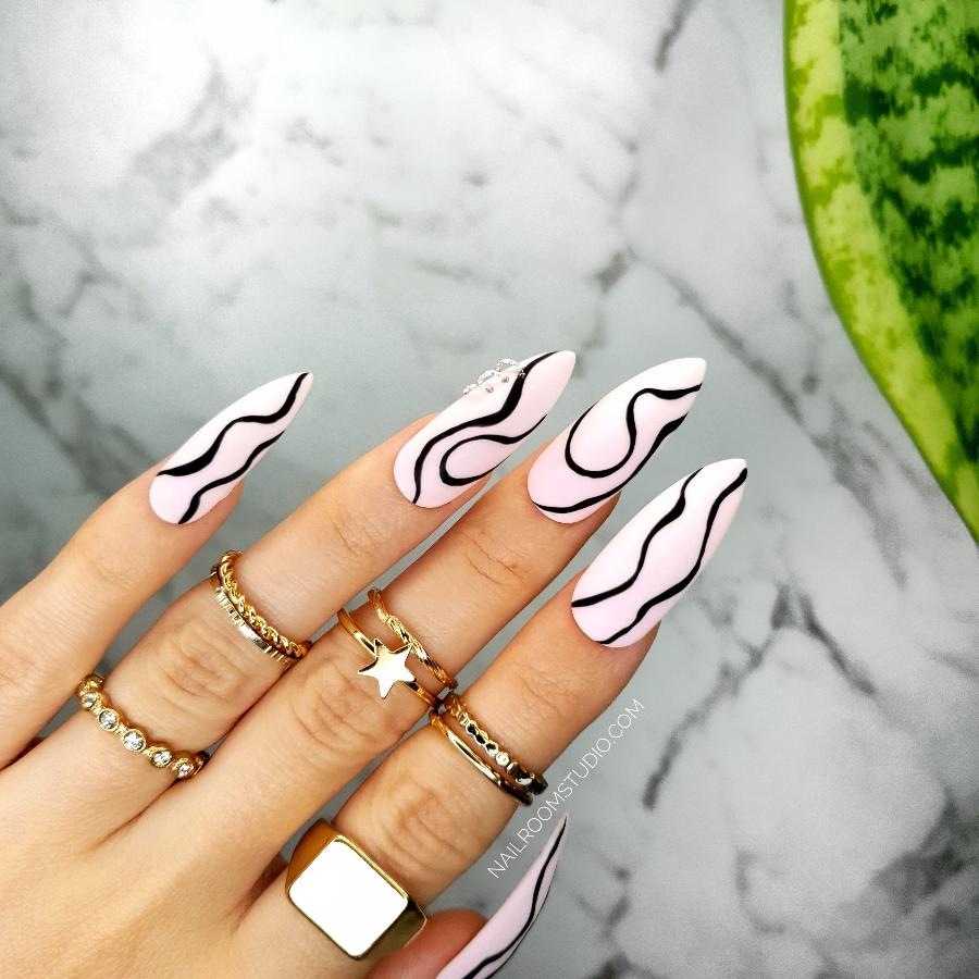 Long stiletto nails in powder pink with hand-painted black waves, great for spring and summer manicures and pedicures with prep kit or glue from Nail Room Studio