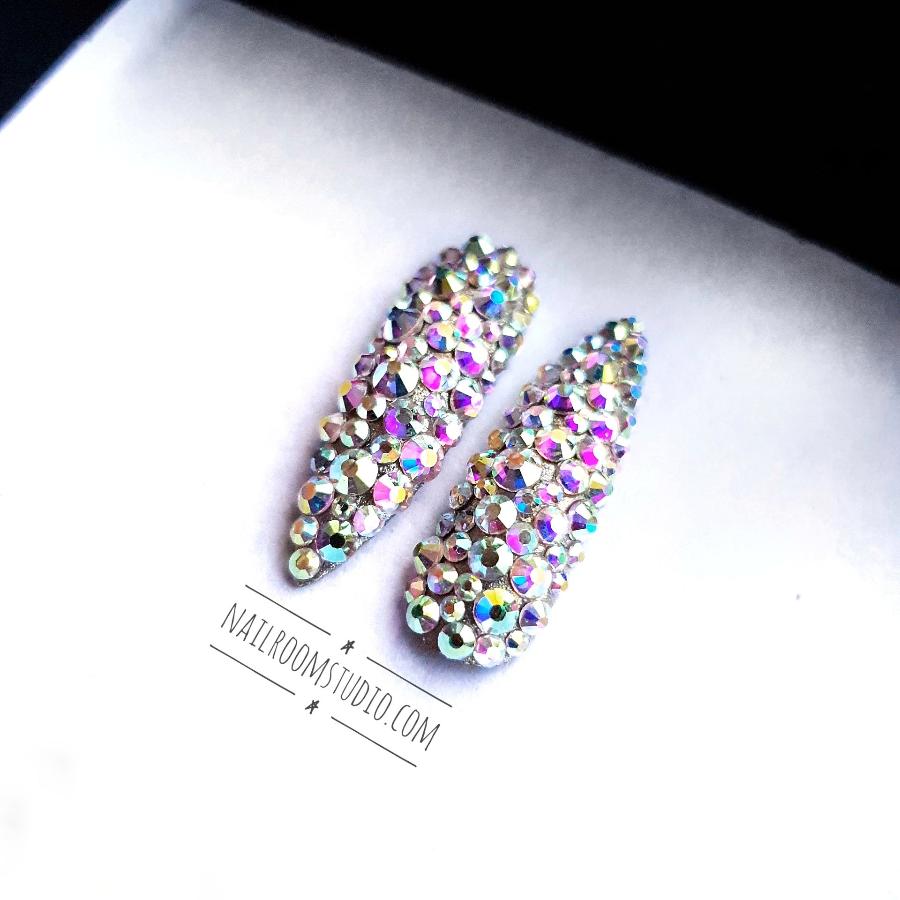 Luxury stiletto nails adorned with original Swarovski crystals and iridescent silver accents by Nail Room Studio