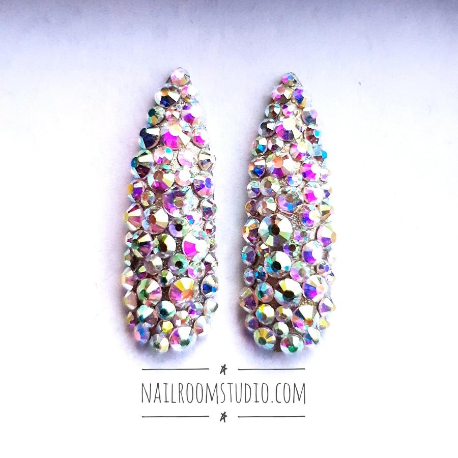 High-end stiletto nails featuring Swarovski crystals and opalescent silver accents, crafted by Nail Room Studio