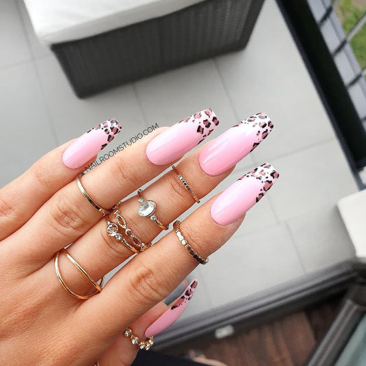 Whimsical pink kawaii nails with creatively painted leopard patterns, perfect for expressing your playful side by Nail Room Studio