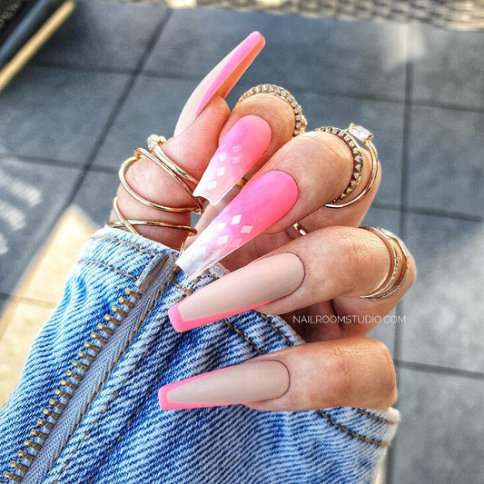 Long coffin nails in neon pink with ombre and French accents, with a partially transparent tip, providing a vibrant and juicy summer look by Nail Room Studio