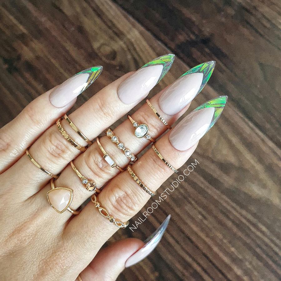 Stylish long nude stiletto nails with modern broken glass accents and iridescent hues by Nail Room Studio