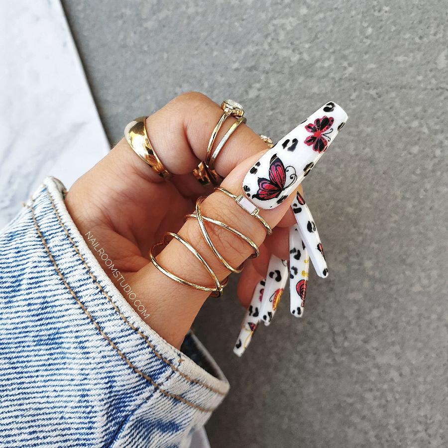 White nails adorned with red roses and butterflies, perfect for summer occasions, false nails set from Nail Room Studio