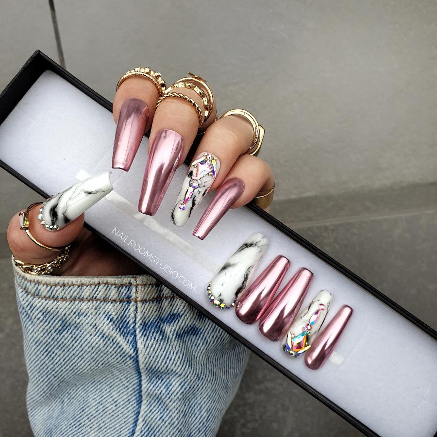 Handmade acrylic lilac and pink nails adorned with beautifully shining crystals, featured on a hand with a stunning glossy finish