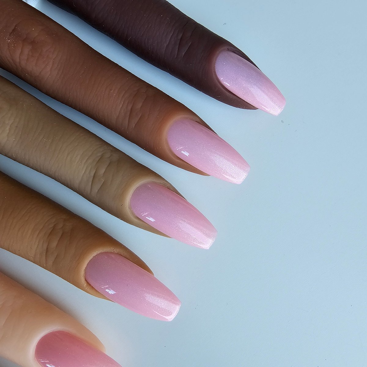 Vibrant glittery barbie pink press-on nails with a pearly sheen, perfect as a French cover with a bold, bubblegum color, matching toes and hands, skin tones color swatches