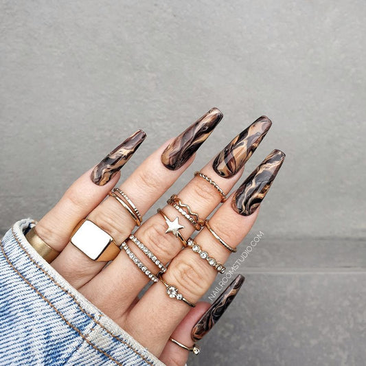 Unique nails in brown color with a marble pattern in deep shades, perfect for elegant styling