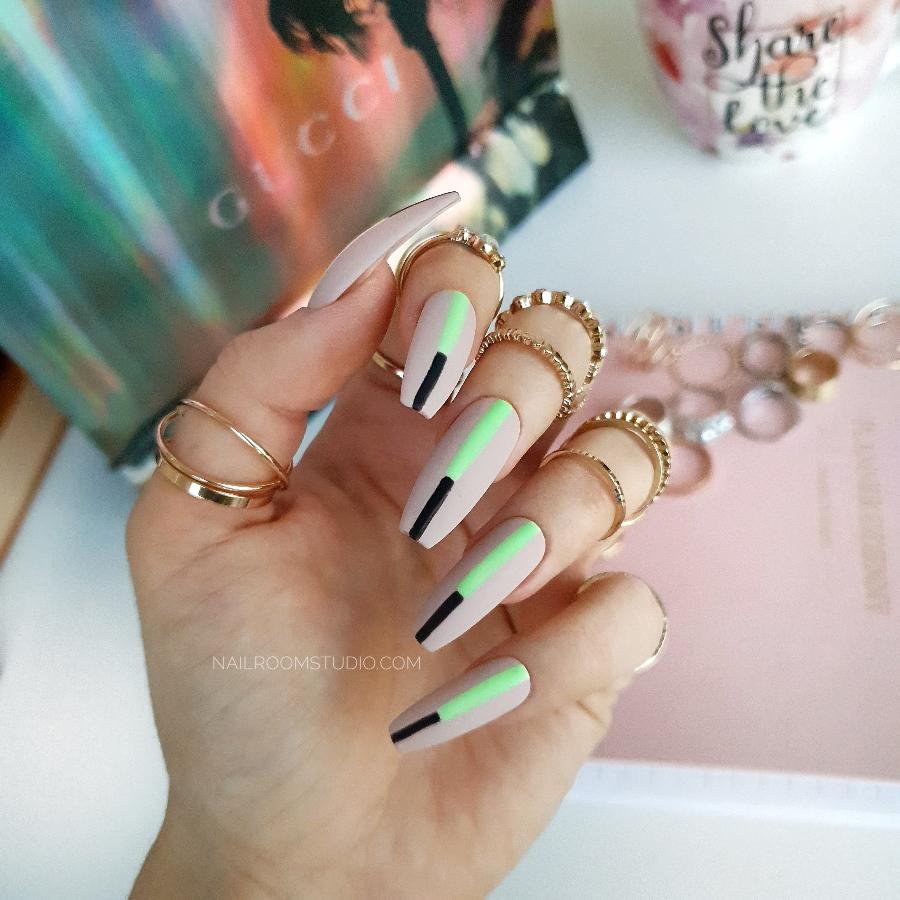 Nude nails with bold neon lime green and black accents, a modern and minimalist look without the traditional French