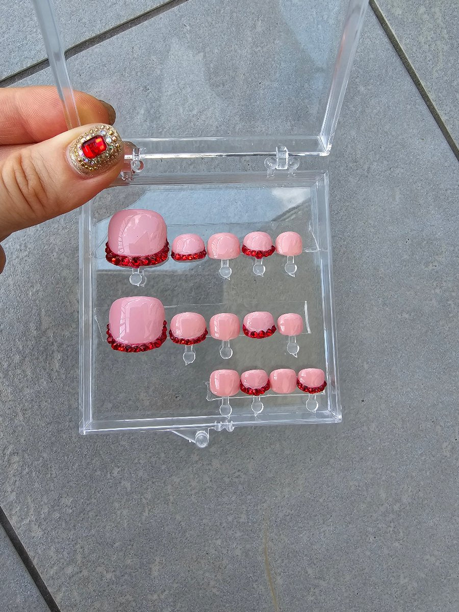 Powder pink nails with red French tips, handmade, featuring Swarovski crystals, packaged in a clear box from Nail Room Studio