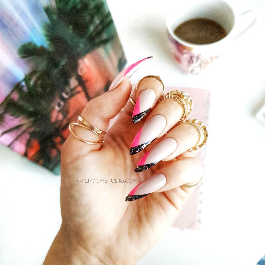 Beige French nails with pink and black geometric tips and glitter accents, creating a stylish, modern look