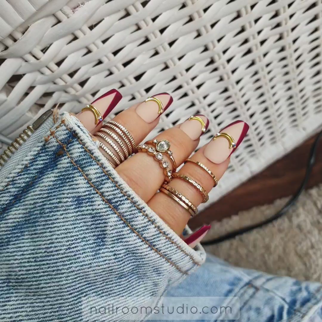 Elegant nude nails with a rich burgundy French tip in a matte finish for a chic, modern look by Nail Room Studio