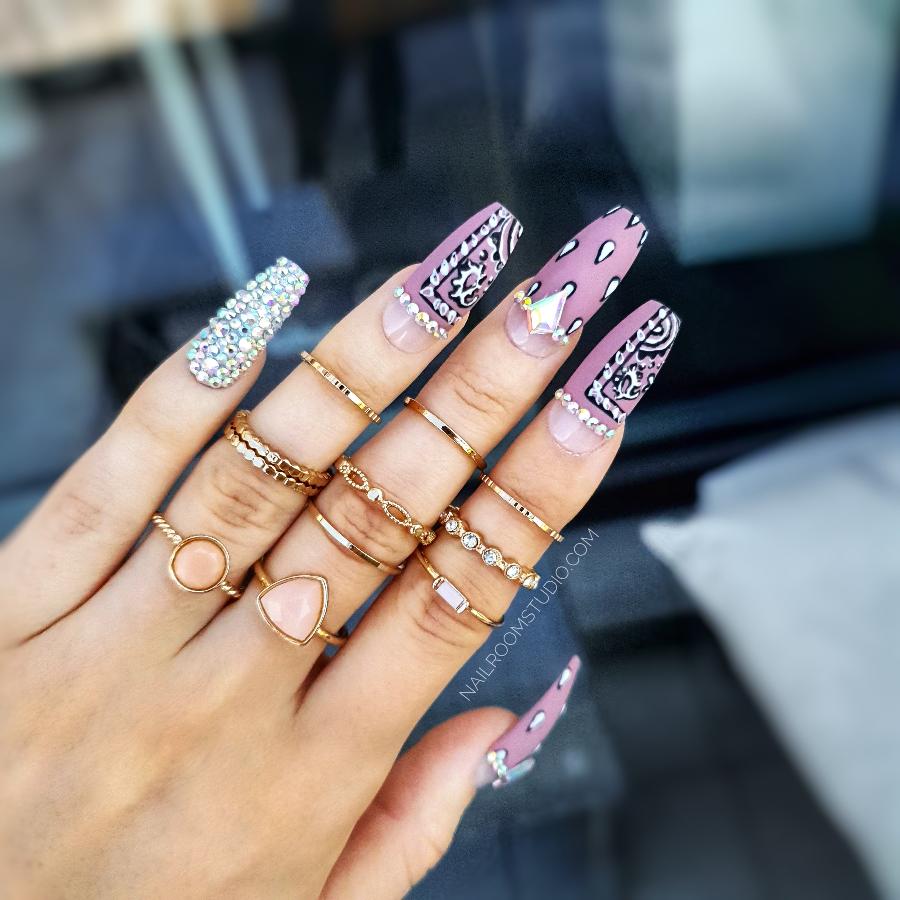 Classic matte purple nails embellished with Swarovski crystals in silver and opal, presented in long stiletto style