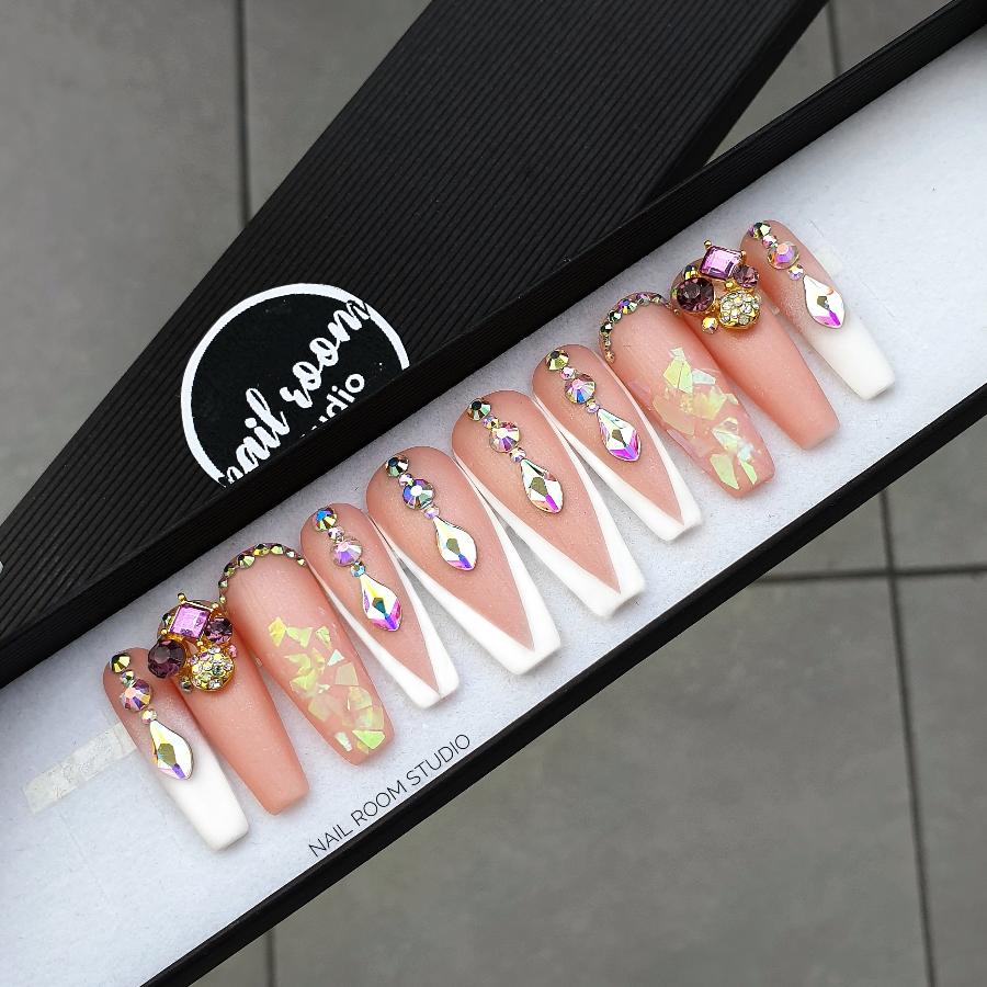 Elegant peach matte French nails adorned with Swarovski crystals by Nail Room Studio