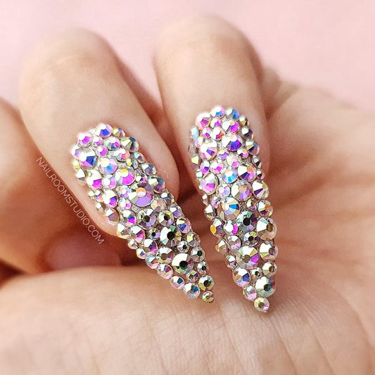 Stiletto nails embellished with genuine Swarovski crystals and a silver iridescent shimmer by Nail Room Studio