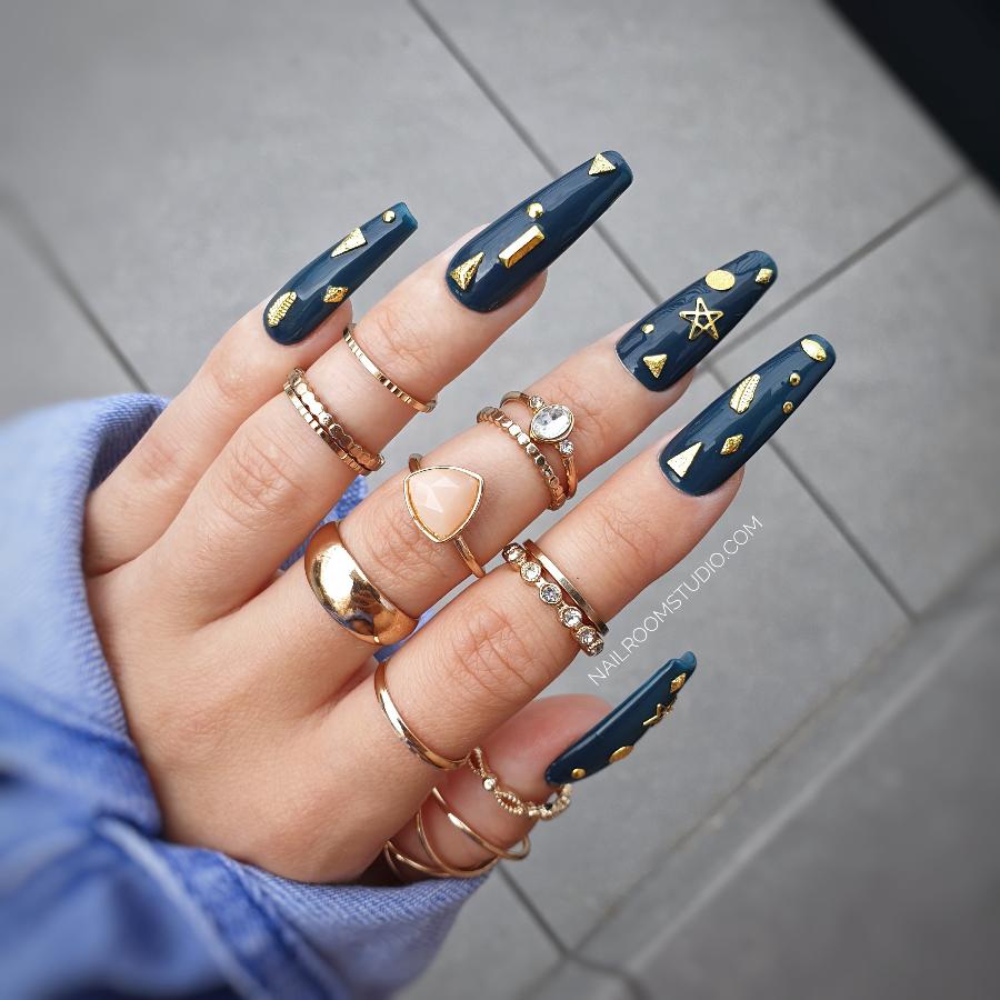 Nail Room Studio sculpted long coffin nails in deep bottle green with gold metallic charms and celestial elements like stars and moons, witchy gothic style nails