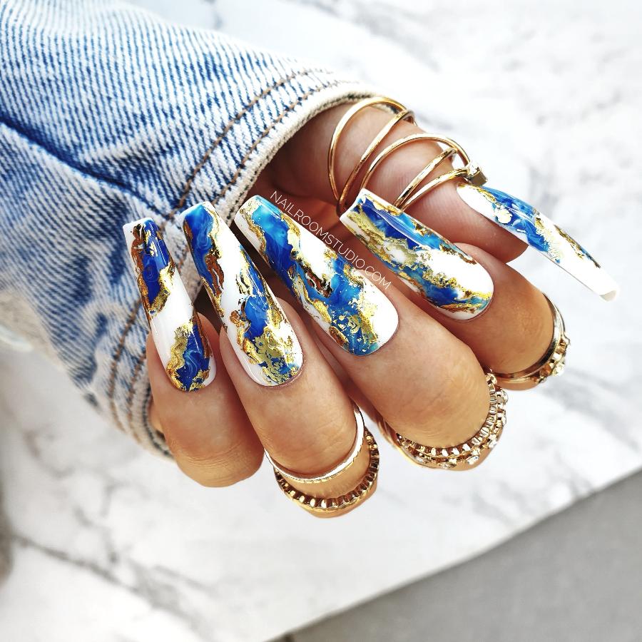 Navy and blue press-on nails by Nail Room Studio with gold chrome, wavy design, and marble effect, in a long sculpted coffin shape for mani-pedi set, nails of Turkiye