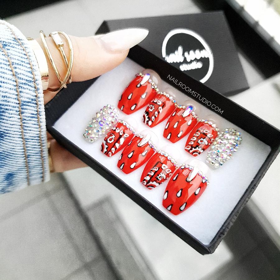 Short coffin nails in red with Swarovski crystals and hand-painted bandana designs by Nail Room Studio