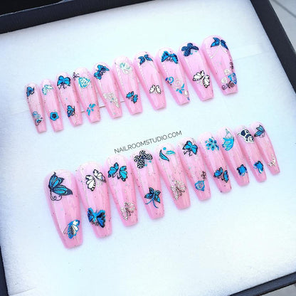 Vibrant pink summer nails in a full set of 20, showcasing long sculpted cupping with silver and blue butterfly accents, and multicolor glitter, ready for the beach in Australia from Nail Room Studio