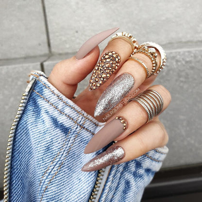 Matte finish light beige nails in cappuccino and hazel tones, with one accent nail filled with brown Swarovski crystals, from Nail Room Studio