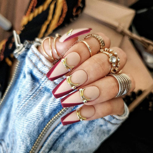 Matte nude nails with striking burgundy French tips, adding a touch of elegance to any outfit by Nail Room Studio