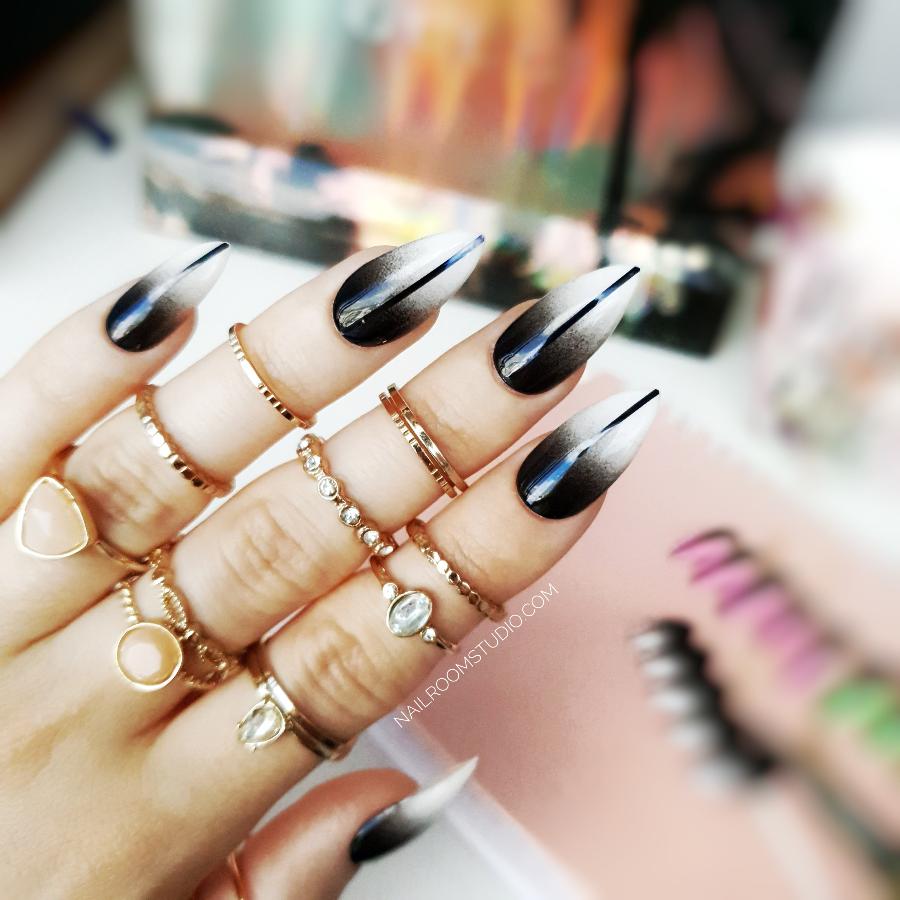 Black and white ombre stiletto nails with a bold black line for a witchy Halloween style by Nail Room Studio