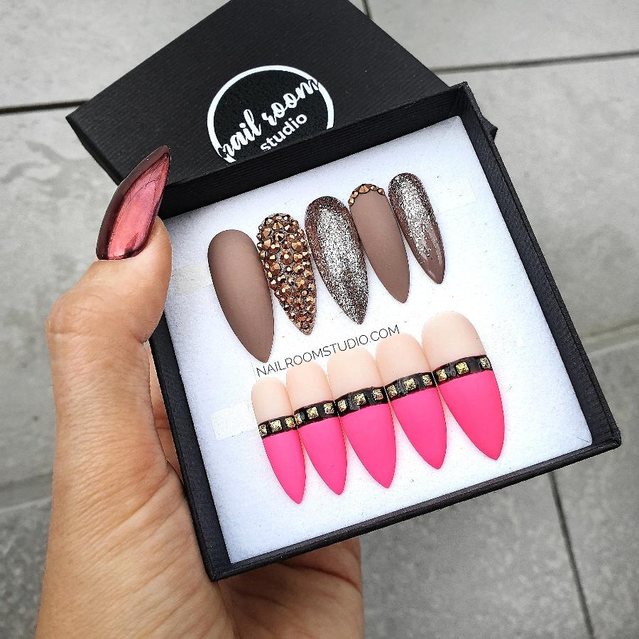 Ultra pink faux kinky nails with nude pink tips, black stripe, and gold gems by Nail Room Studio, ideal for darker skin tones