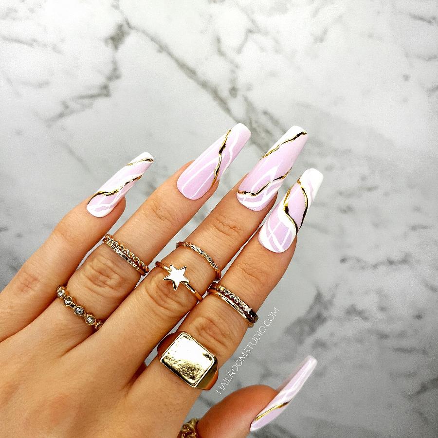 Long sculpted coffin press-on nails in soft pink and white, with a hand-painted white marble design, golden accents, and a glossy finish, ideal for both manicure and pedicure with a wave-inspired design