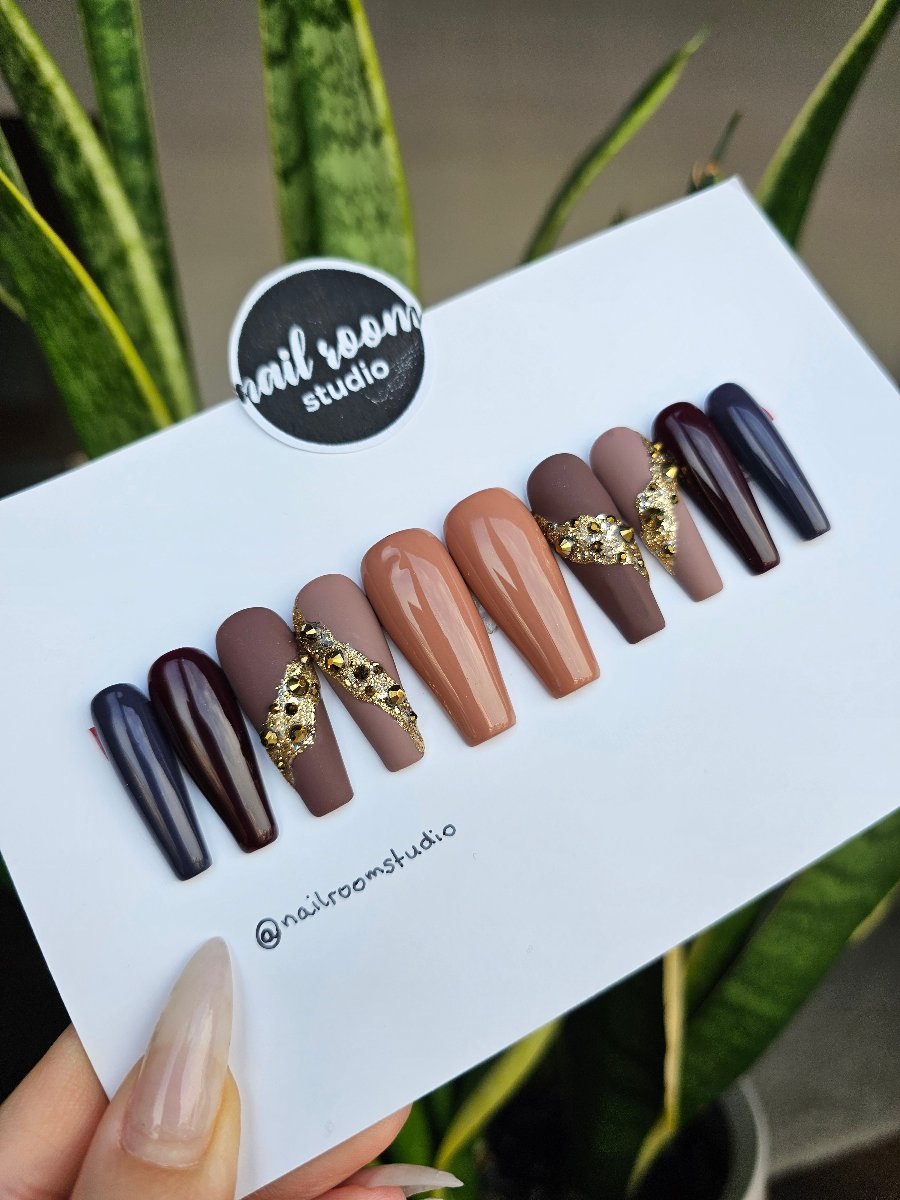 Autumn nails in brown tones with matte and glossy finishes, enhanced by 3D Swarovski crystals, resembling volcanic lava, easy-to-apply long coffin press-on nails