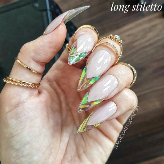 Nude stiletto nails with a unique broken glass look and iridescent tones of gold, green, and blue from Nail Room Studio