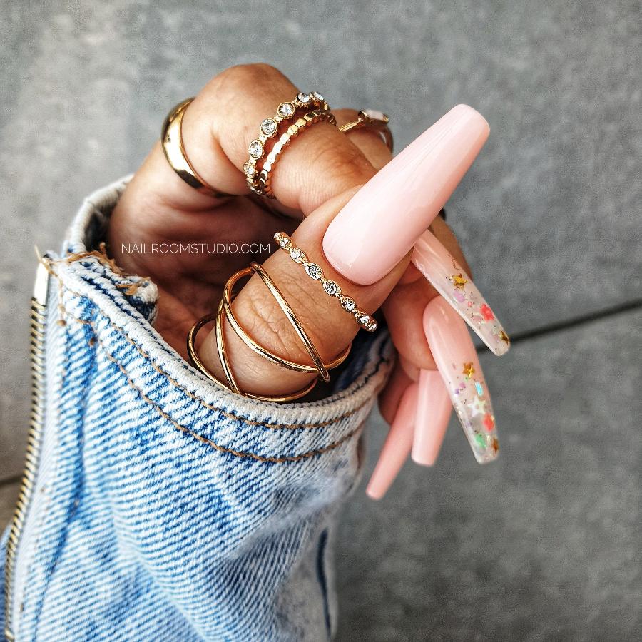 Pastel pink long coffin nails with delicate ombre and glitter, featuring a partially transparent design, perfect for spring and summer looks by Nail Room Studio