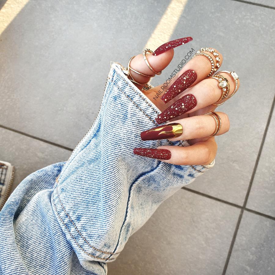 Luxurious matte glitter nails with gold chrome flame accents, available in various shapes, lengths, and sizes with matching toe tips, exclusive burgundy press ons, designed for a bold, sophisticated look by Nail Room Studio