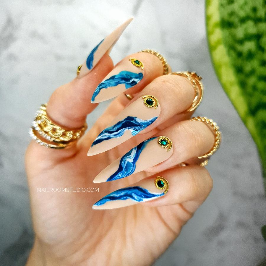 Sharp matte nude press-on nails with blue marble and golden accents, finished with Swarovski crystals for a stylish look hand made by Nil Room Studio