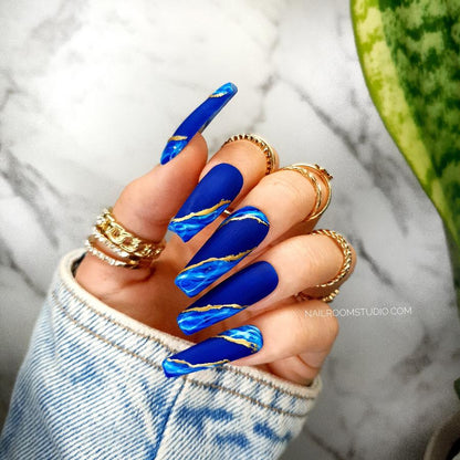 Navy blue French-style nails with gold and blue marble accents, matte finish, perfect for elegant hands and toes