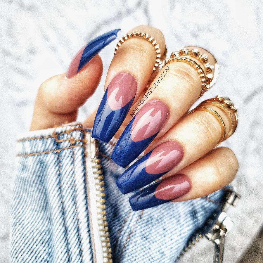 Stylish navy blue nails with subtle natural French tips, offering a sophisticated edge by Nail Room Studio