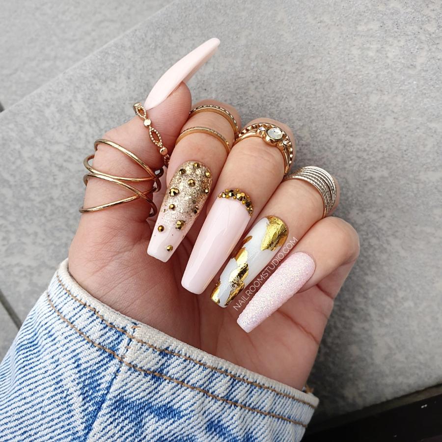 Reusable glossy pink Press-On nails featuring gold chrome details and long coffin shape