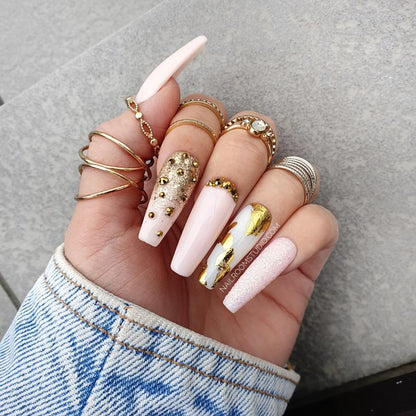 Reusable glossy pink Press-On nails featuring gold chrome details and long coffin shape