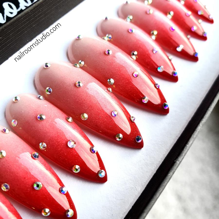 Red ombre long stiletto faux nails featuring silver crystals and dotted accents by Nail Room Studio