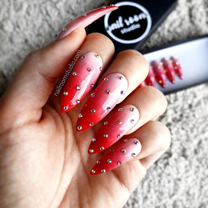 Elegant red and nude ombre stiletto nails with dotted accents and small silver crystals by Nail Room Studio