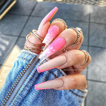 Long coffin nails in neon pink with ombre and French accents, with a partially transparent tip, providing a vibrant and juicy summer look by Nail Room Studio