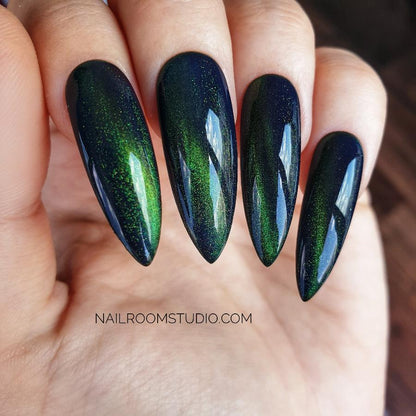 Long stiletto nails in dark bottle green with a cat-eye shimmer, inspired by wizard and witchy aesthetics from Nail Room Studio