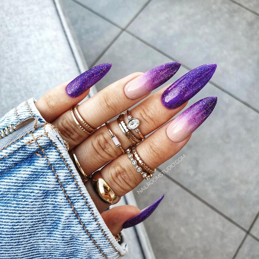 Long stiletto nails in a purple ombre with nude and glittery accents, crafted for those embracing the witchy viccan vibe, exclusively by Nail Room Studio