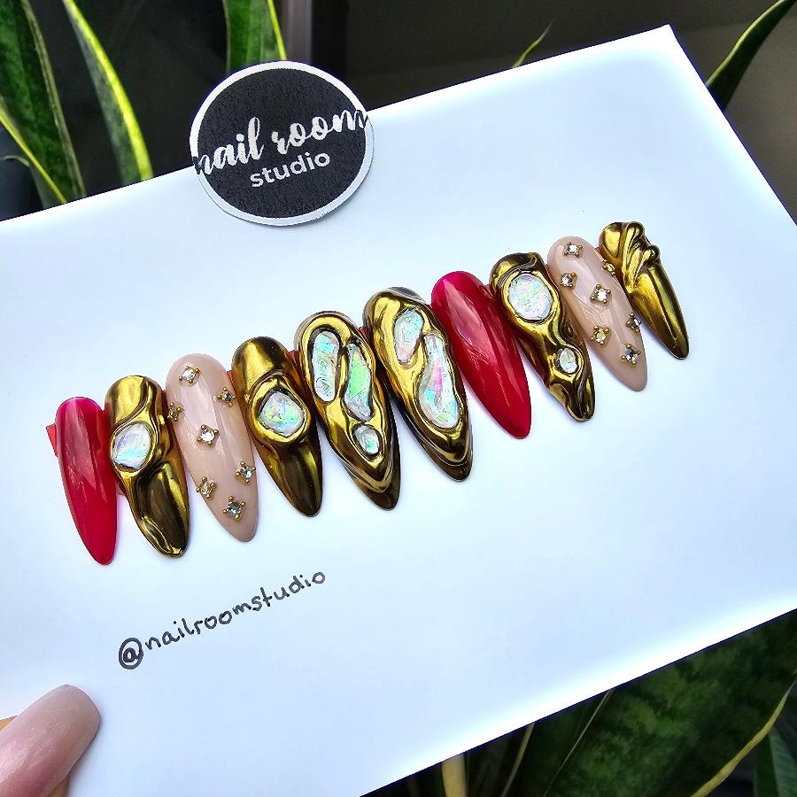 Chic golden chrome press-on nails with a magical sphere look, matte nude undertones, embellished with pearls and crystals, and a burgundy hue that adds a witchy vibe, perfect for special occasions