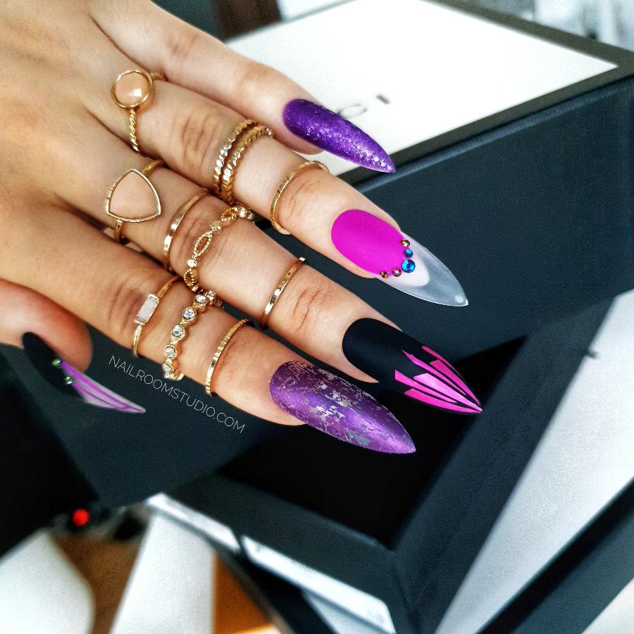 Long purple stiletto nails with chrome and black accents, featuring raindrop and crystal details for a witchy, mystical style