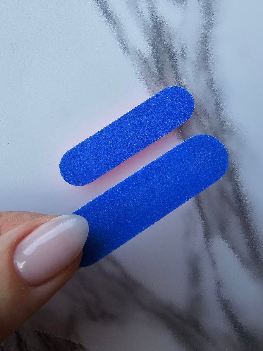 Compact blue and navy double-sided mini nail files, perfect for quick touch-ups and convenient for on-the-go nail care