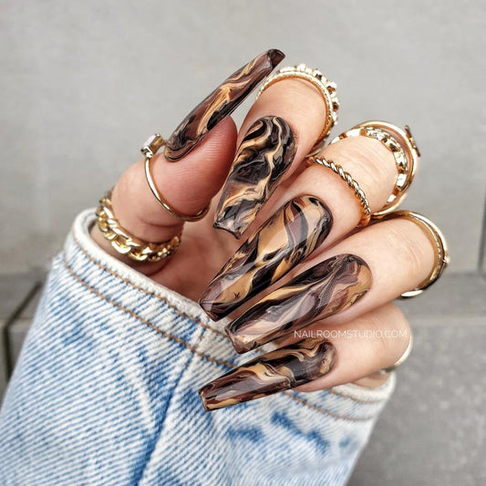 Elegant brown marble nails featuring intricate swirling patterns