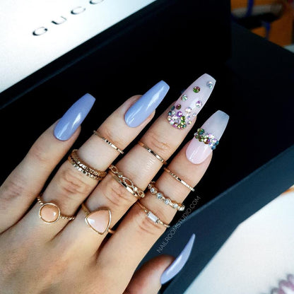 Beautiful lilac nails with accents of powder pink and colorful Swarovski crystals, designed for a graceful and elegant appearance