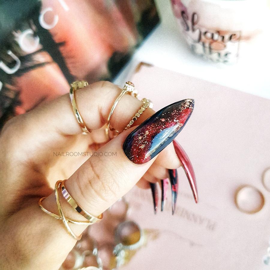 Dark red and burgundy nails with black and chrome water painting, creating a magical, mysterious look